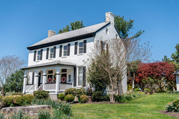 White two-story farmhouse with porch wreaths