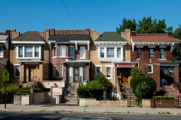 Sunlit brick rowhouses with front stoops