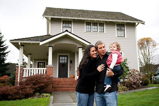 Family celebrating in front of new home